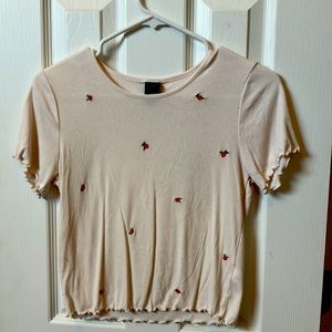 It is a cream colored shirt with roses. Has never been warn, in good condition